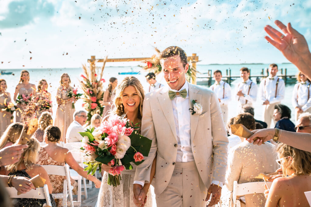 Couple exits ceremony site during a petal toss.